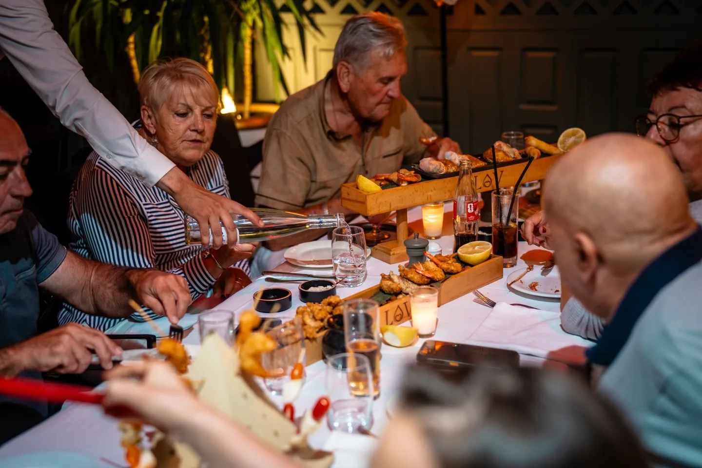 Guests sharing dishes around a candlelit table at LOV