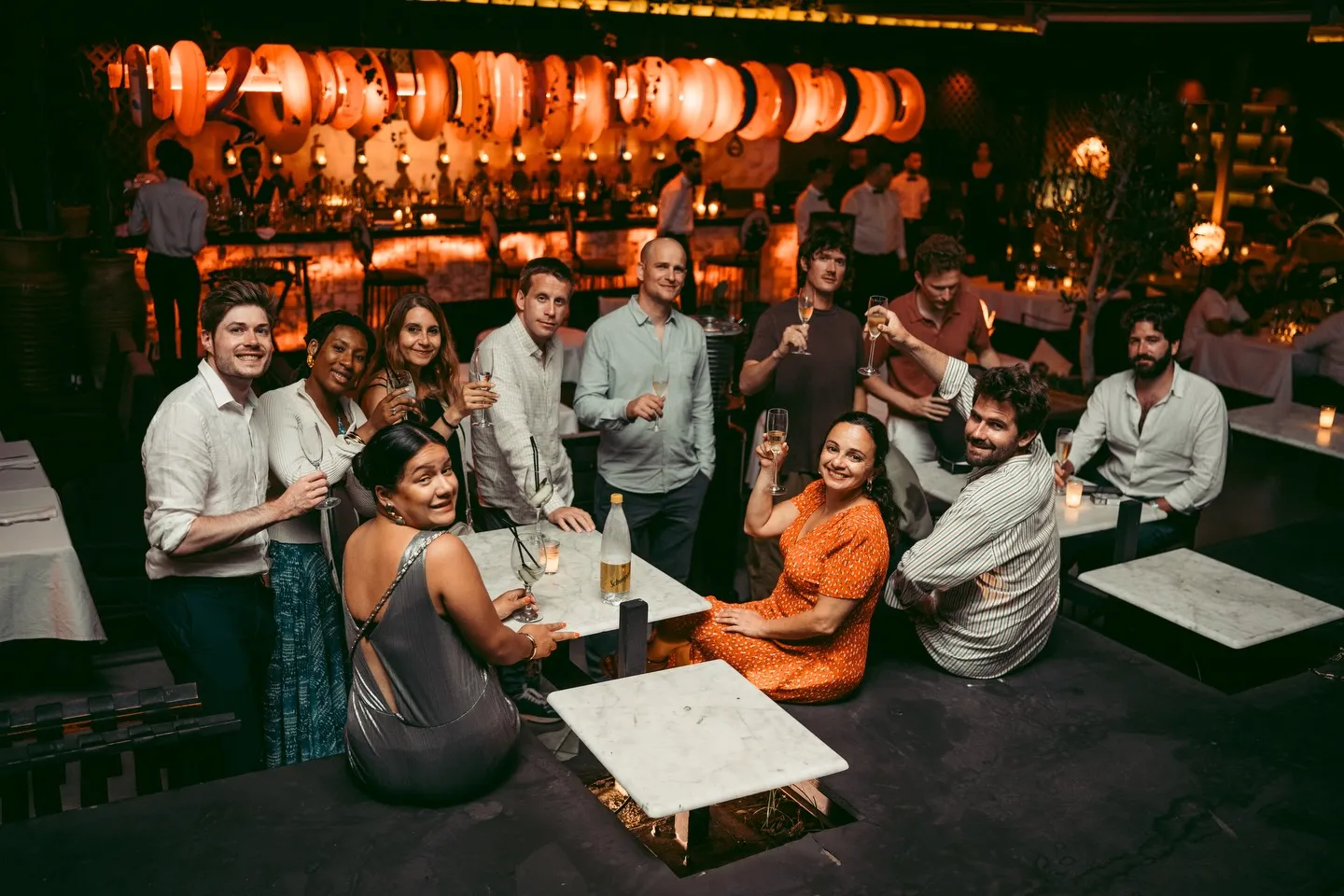 Guests raising glasses together under the lanterns at LOV